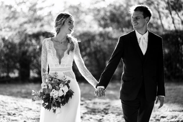 Gli sposi si tengono per mano e si guardano intensamente in un ritratto in bianco e nero durante il matrimonio Borgo della Rocca.