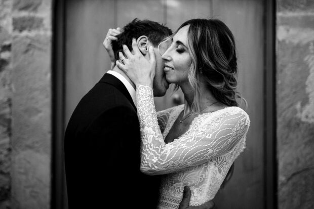 Gli sposi si scambiano un bacio intimo e passionale, un momento di forte emozione nel matrimonio Borgo della Rocca.