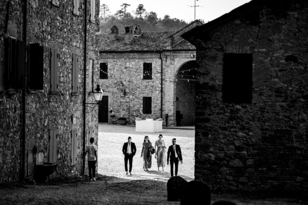 Gli invitati attraversano il cortile interno del Borgo della Rocca, pronti a celebrare un matrimonio da sogno.