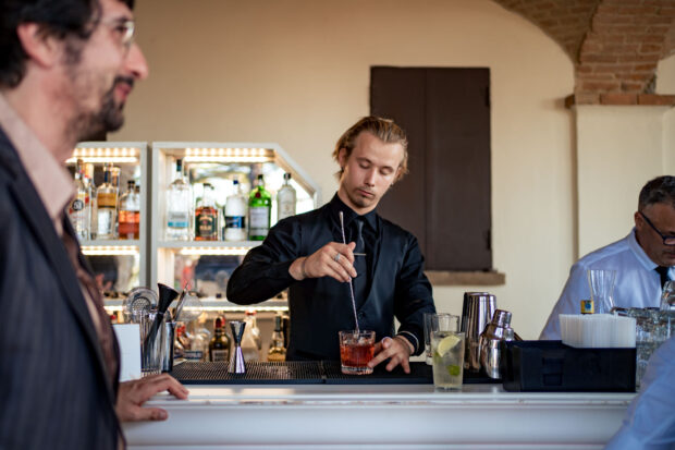 Un barman prepara cocktail raffinati per gli ospiti del matrimonio Borgo della Rocca.