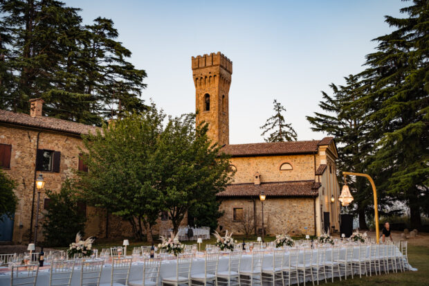 La cena all’aperto con tavolo imperiale nel cortile del Borgo della Rocca, illuminata da luci soffuse.