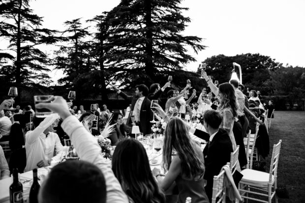 Gli invitati brindano con entusiasmo al matrimonio Borgo della Rocca, celebrando gli sposi.