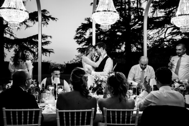 Gli sposi si guardano negli occhi in un momento intimo al tavolo nuziale nel matrimonio Borgo della Rocca.