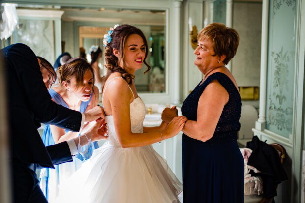 La sposa indossa l’abito aiutata dai familiari