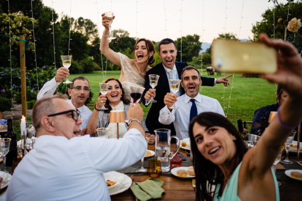 Gli sposi brindano insieme agli amici tra risate e allegria.
