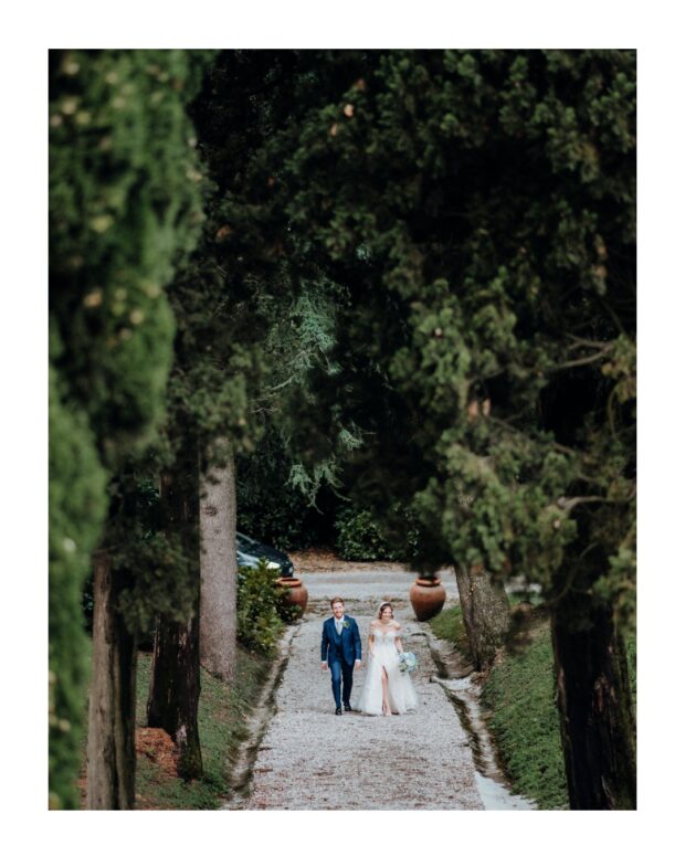 Sposi camminano lungo il viale alberato di Villa Subaglio