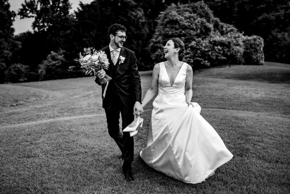 Carolina e Giulio camminano sorridenti mano nella mano, ritratto in bianco e nero