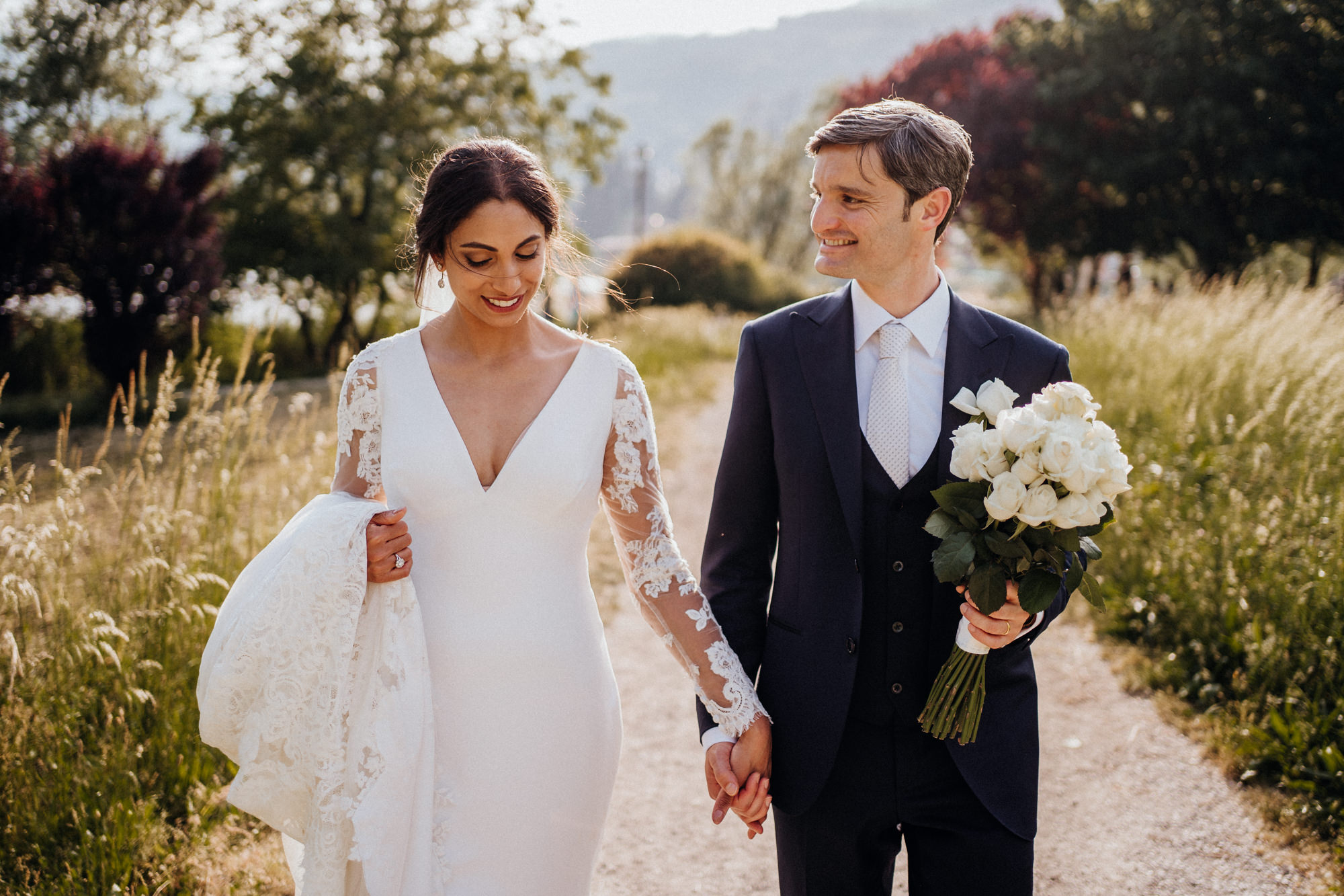 Fotografo matrimonio Castello di Monasterolo – sposi al tramonto camminano mano nella mano