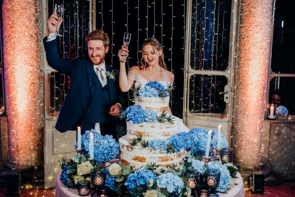 Taglio torta matrimonio con brindisi degli sposi e calici alzati